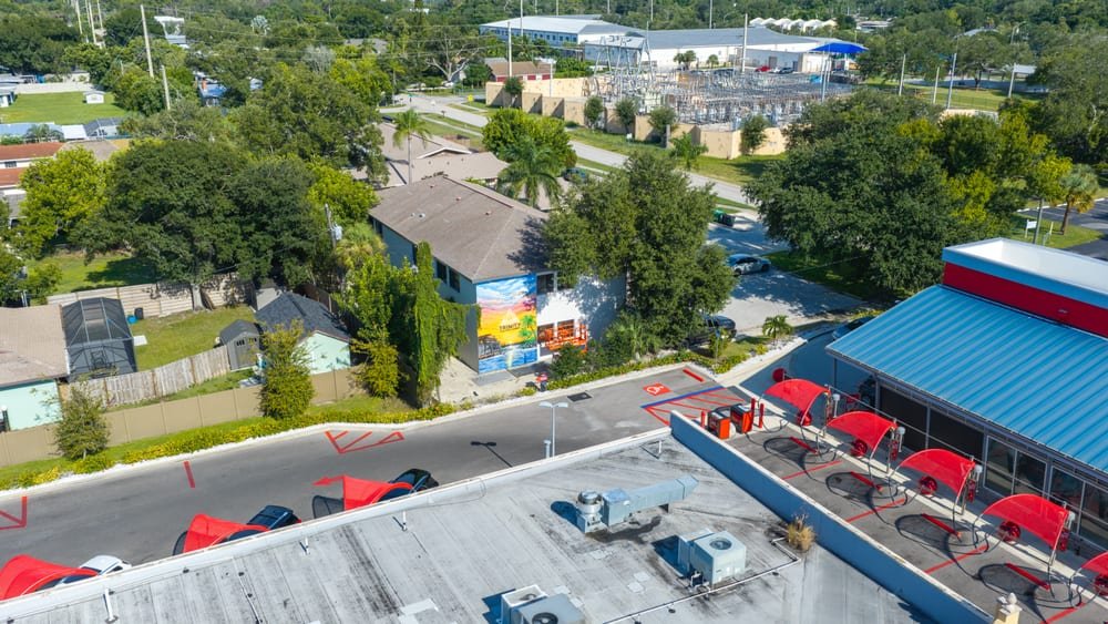 Wide aerial view of a Florida commercial district with rooftops, patios and parking areas